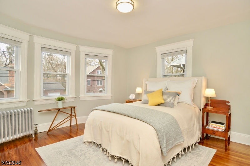 44 Dunnell Road Maplewood, NJ 07040 - Photo 8 of 18 a bedroom with a bed and wooden floor