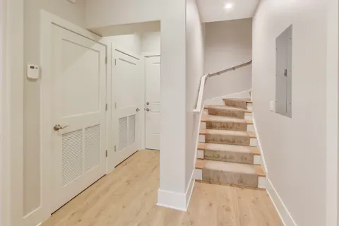 a view of a bedroom with wooden floor and staircase