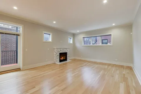 a view of empty room with wooden floor and fireplace