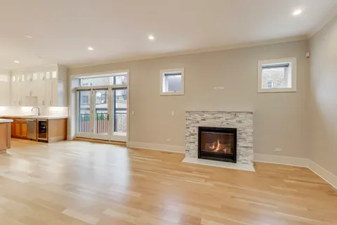 a view of a livingroom with a fireplace window and wooden floor