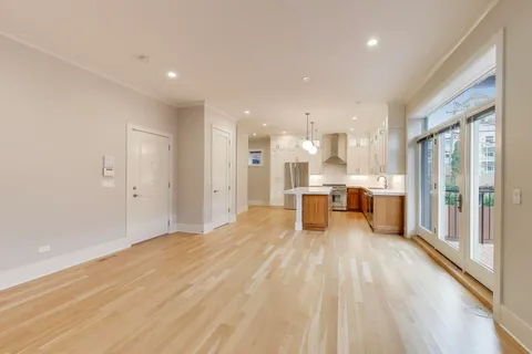 a view of a kitchen with stainless steel appliances wooden floor and a window