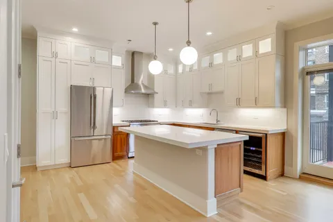 a kitchen with stainless steel appliances granite countertop a sink a stove and a refrigerator