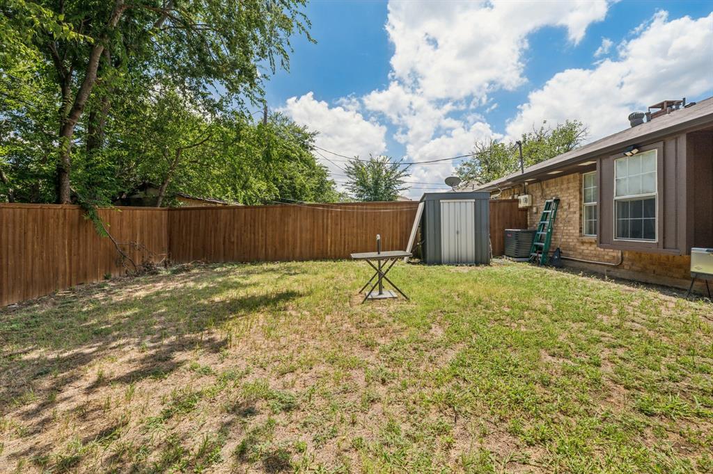 9780 Windy Ridge Road Frisco, TX 75033 - Photo 19 of 25 Spacious backyard featuring a full wood privacy fence, a metal storage shed, and mature trees providing shade