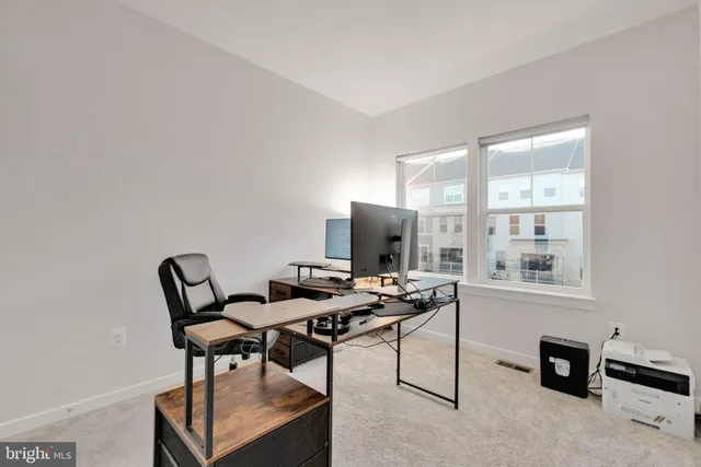 a view of a workspace with furniture and a window