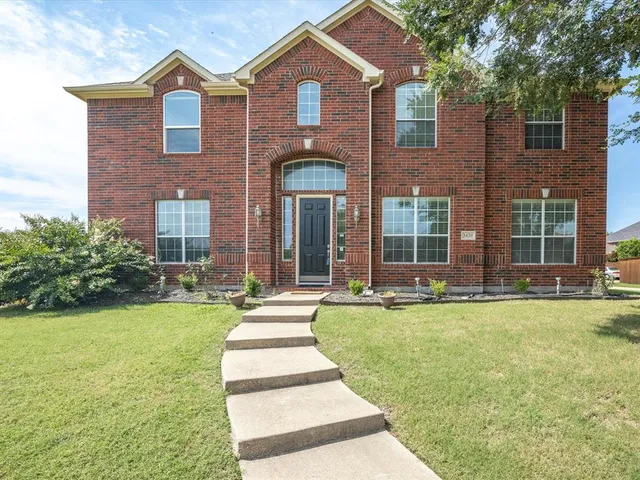a front view of a house with swimming pool and garden