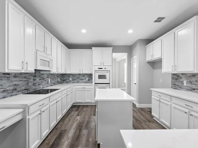 a kitchen with white cabinets appliances and sink
