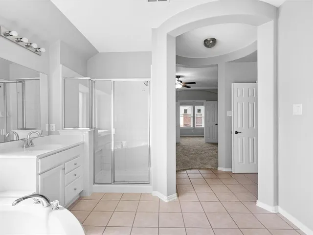 a spacious bathroom with a double vanity sink a mirror and a bathtub