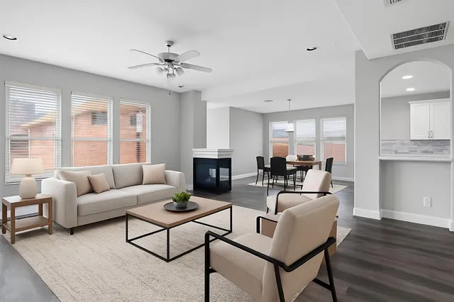 a living room with fireplace furniture and a large window