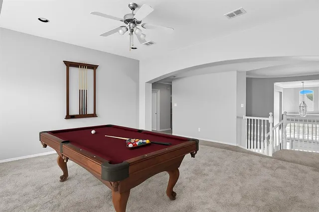 a room with pool table and windows