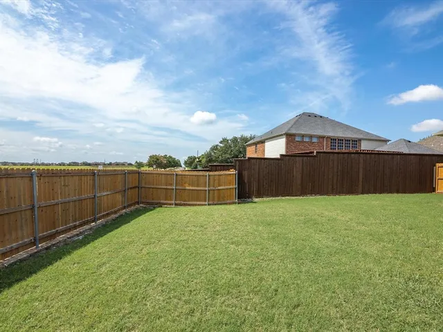 a view of a backyard with wooden fence