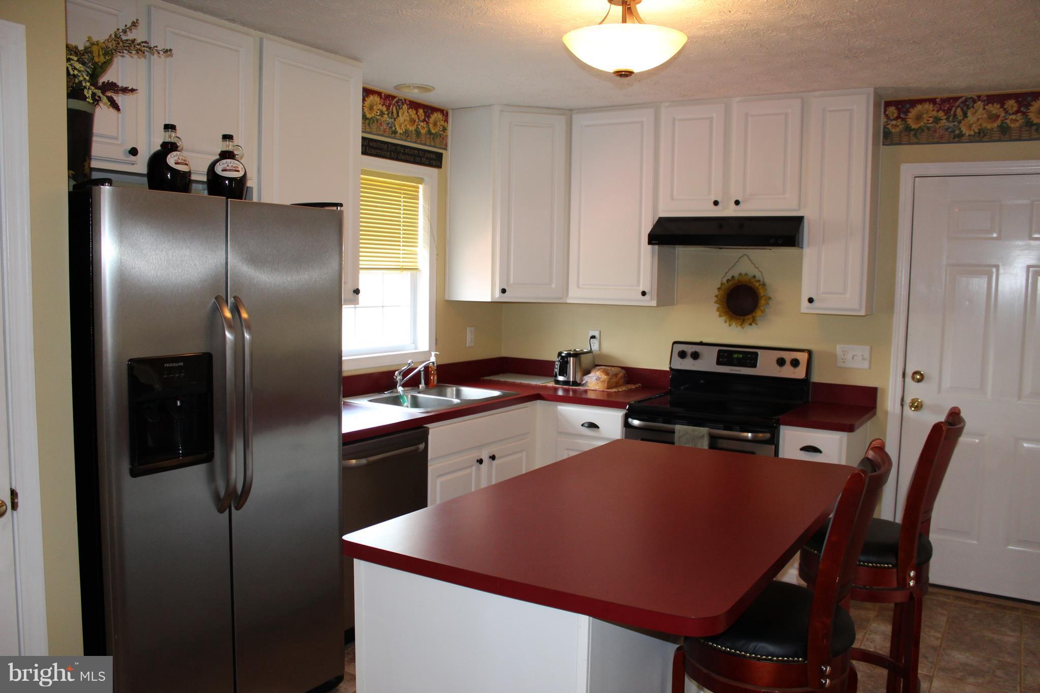 3307 Cabin Road Reva, VA 22735 - Photo 8 of 30 a kitchen with stainless steel appliances granite countertop a refrigerator a sink a stove and white cabinets