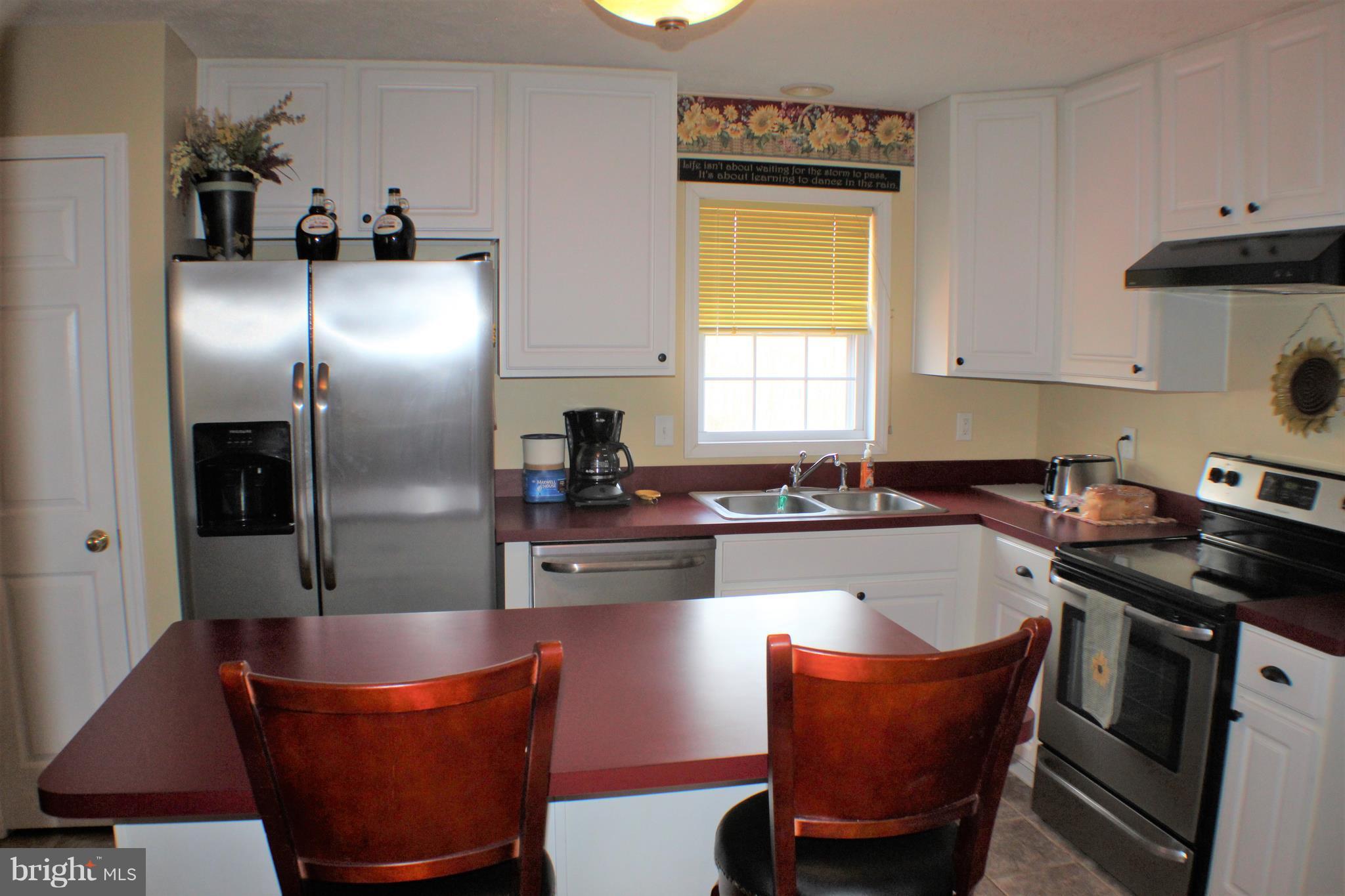 3307 Cabin Road Reva, VA 22735 - Photo 10 of 30 a kitchen with stainless steel appliances granite countertop a sink a stove a refrigerator and a dining table