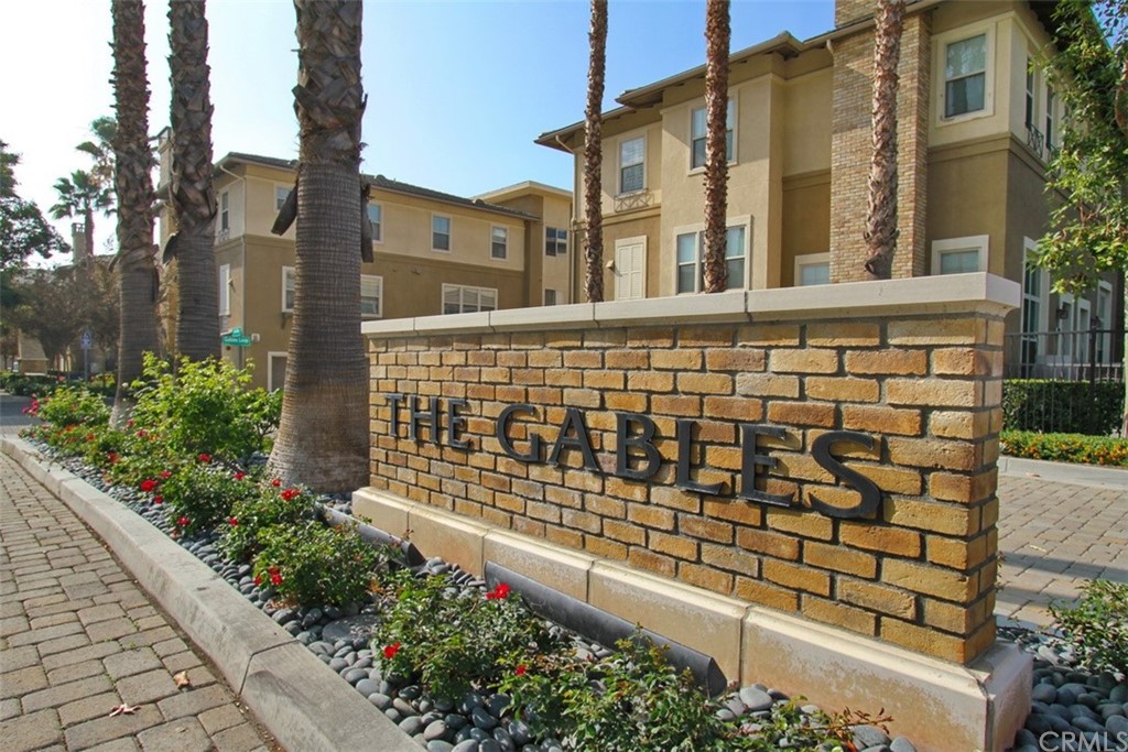 a view of a brick house with a flower garden