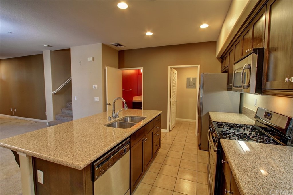 16073 Gables Loop Whittier, CA 90603 - Photo 11 of 31 a kitchen with stainless steel appliances granite countertop a sink and a refrigerator