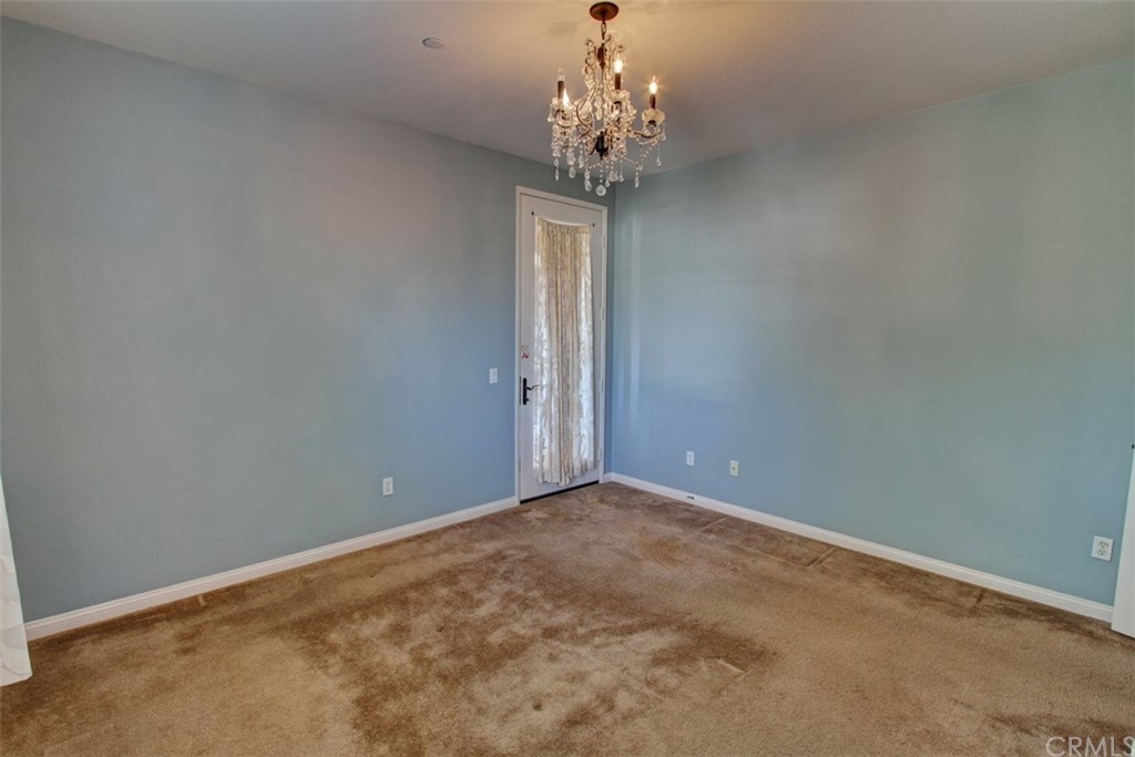 16073 Gables Loop Whittier, CA 90603 - Photo 15 of 31 an empty room with a chandelier fan and windows