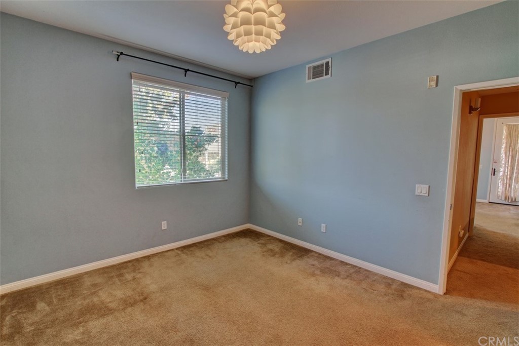 16073 Gables Loop Whittier, CA 90603 - Photo 19 of 31 an empty room with windows and chandelier fan