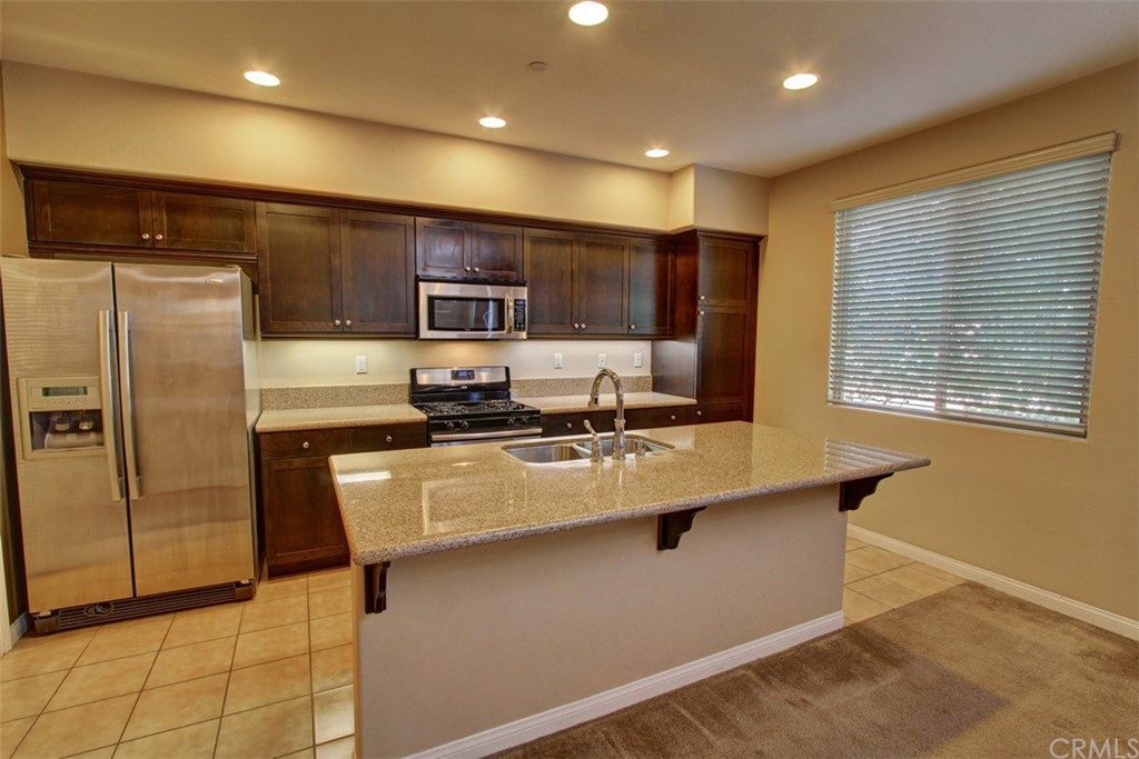 16073 Gables Loop Whittier, CA 90603 - Photo 9 of 31 a kitchen with stainless steel appliances granite countertop a sink refrigerator and microwave