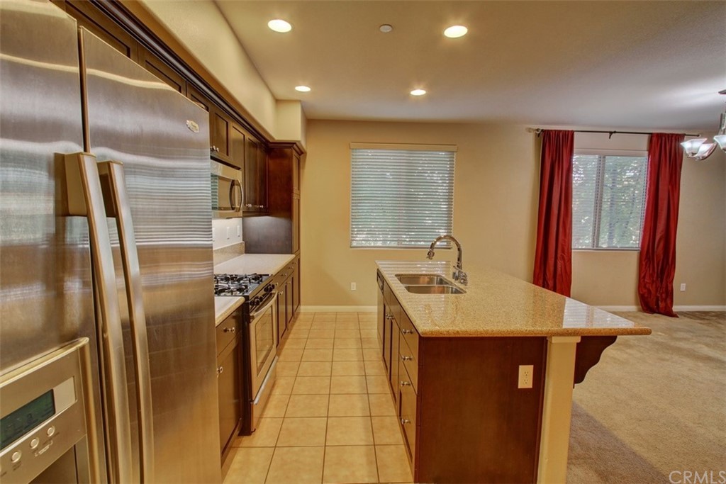 16073 Gables Loop Whittier, CA 90603 - Photo 10 of 31 a kitchen with stainless steel appliances granite countertop a sink a refrigerator and a stove