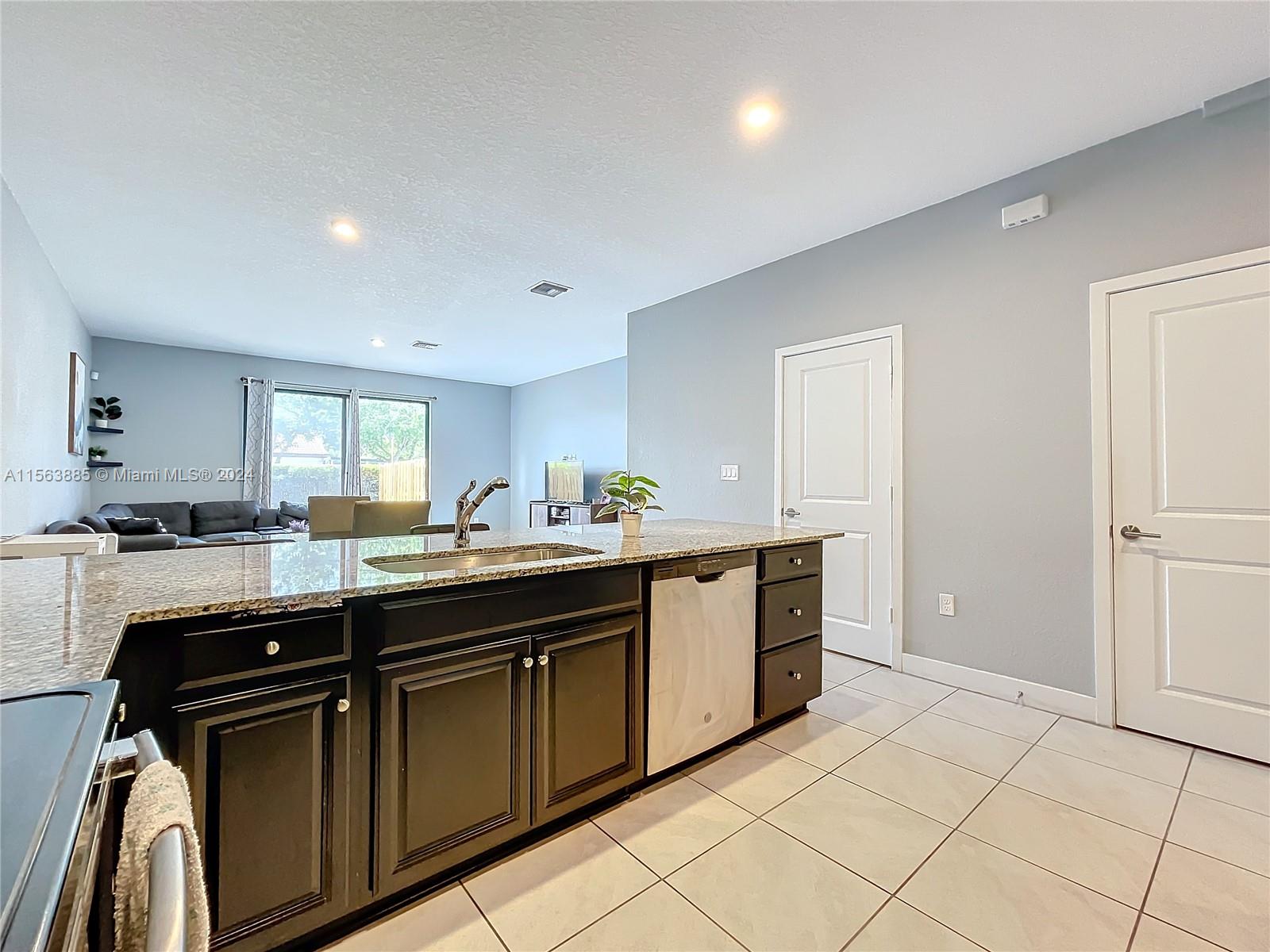10888 Southwest 235th Lane Homestead, FL 33032 - Photo 12 of 36 a kitchen with stainless steel appliances granite countertop a sink and cabinets