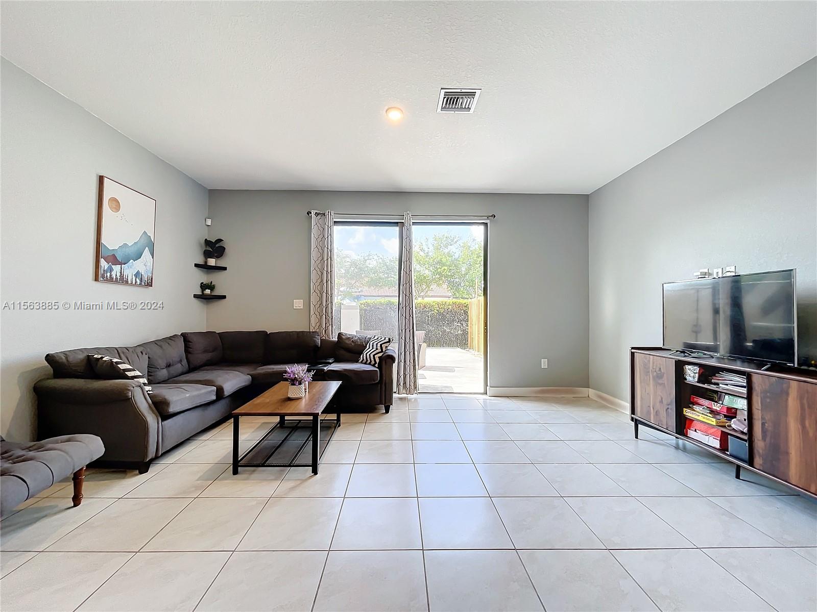 10888 Southwest 235th Lane Homestead, FL 33032 - Photo 18 of 36 a living room with furniture and a flat screen tv