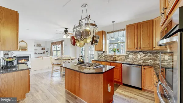 a kitchen with granite countertop a sink a stove and cabinets