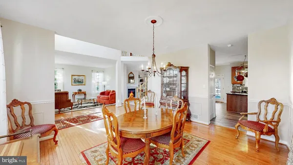 a dining room with furniture a chandelier and wooden floor
