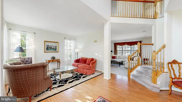 a living room with wooden floor furniture and a potted plant