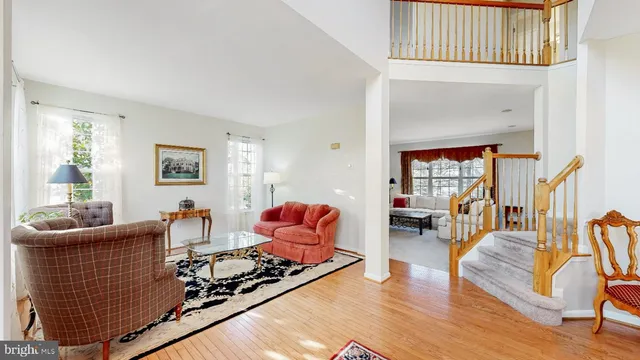 a living room with wooden floor furniture and a potted plant