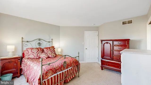 a view of a white house next to a yard with potted plants