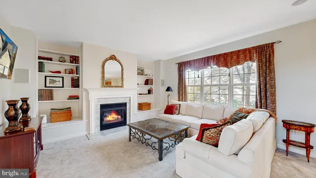 a living room with furniture a fireplace and a large window