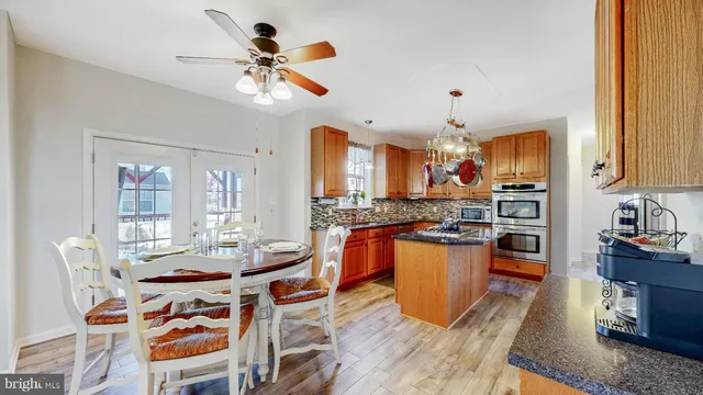 a kitchen with a table chairs stainless steel appliances and cabinets