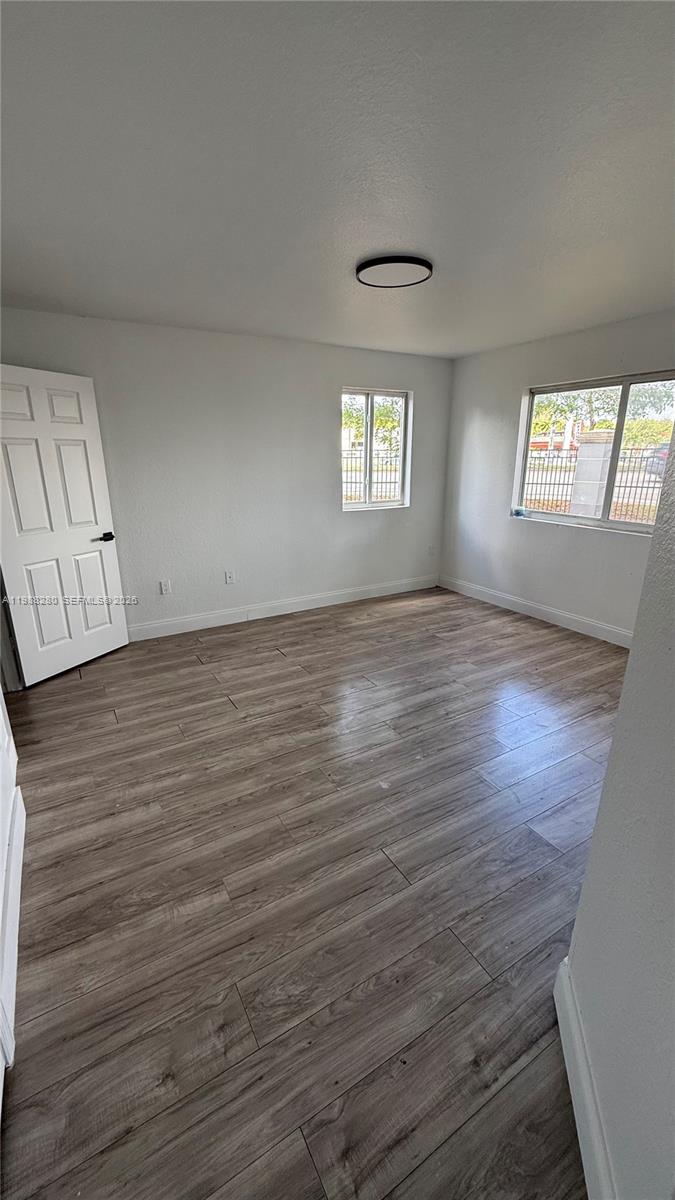15480 Southwest 284th Street, Unit 2111 Homestead, FL 33033 - Photo 1 of 16 an empty room with wooden floor and windows