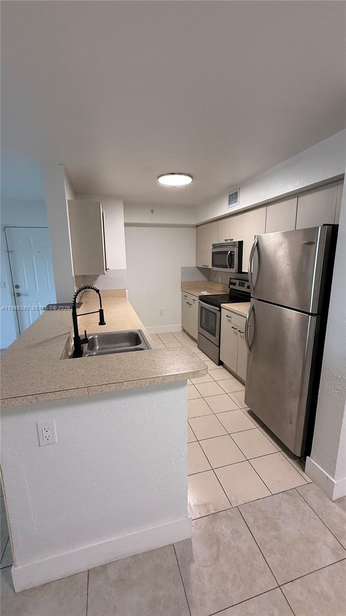 15480 Southwest 284th Street, Unit 2111 Homestead, FL 33033 - Photo 6 of 16 a kitchen with stainless steel appliances granite countertop a refrigerator sink and stove