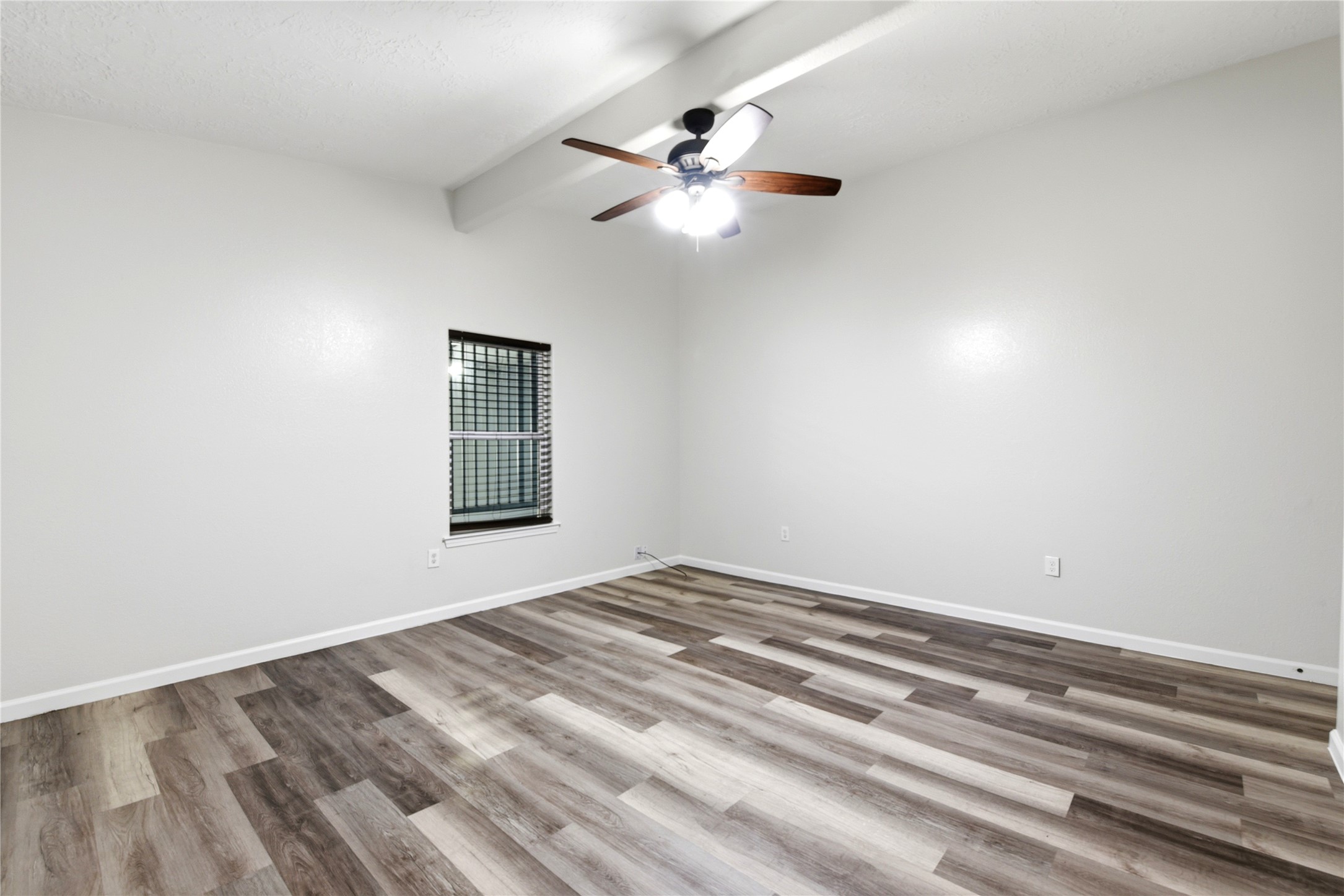 9403 Spaulding Street Houston, TX 77016 - Photo 21 of 50 This room features a modern ceiling fan, sleek wood-look flooring, and a neutral color palette, creating a bright and open space.