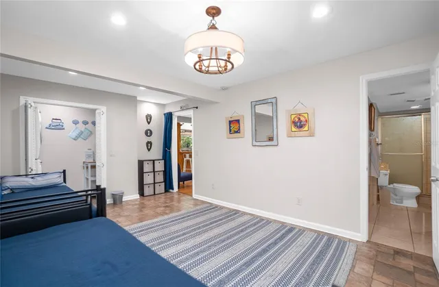 a bedroom with a bed and a chandelier