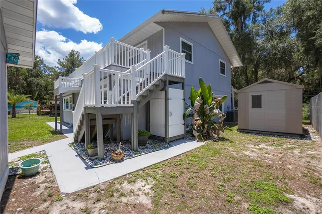 an aerial view of a house with a yard and lake view