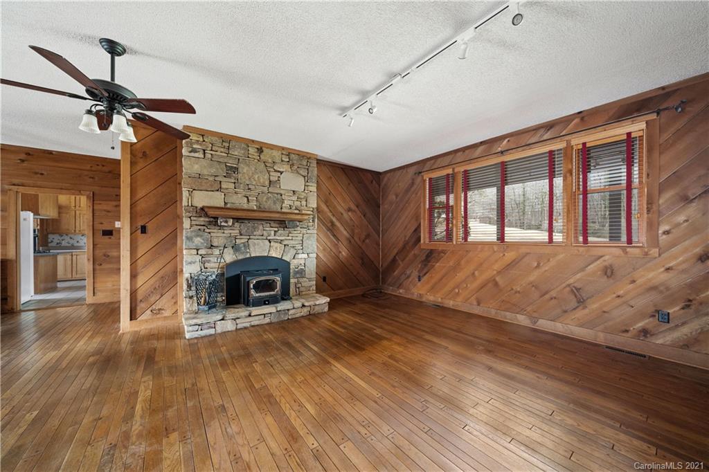 153 Miller Drive Tryon, NC 28782 - Photo 11 of 28 a view of a livingroom with a fireplace a ceiling fan and windows