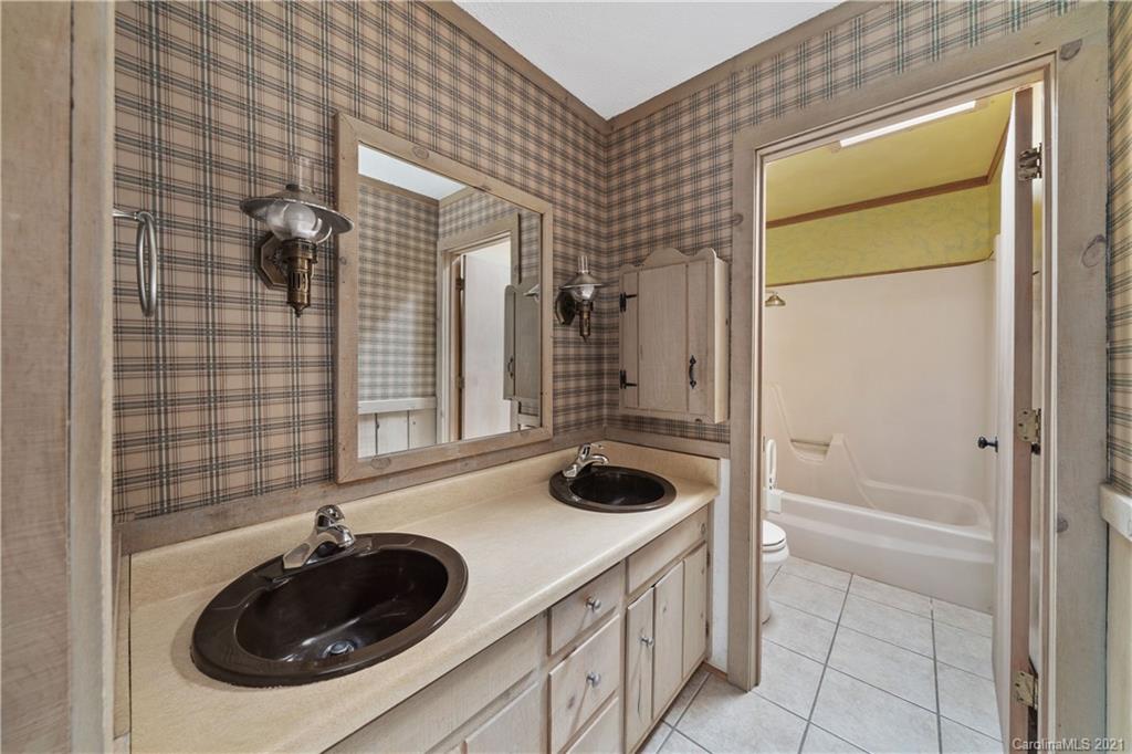153 Miller Drive Tryon, NC 28782 - Photo 18 of 28 a bathroom with a sink a toilet and shower