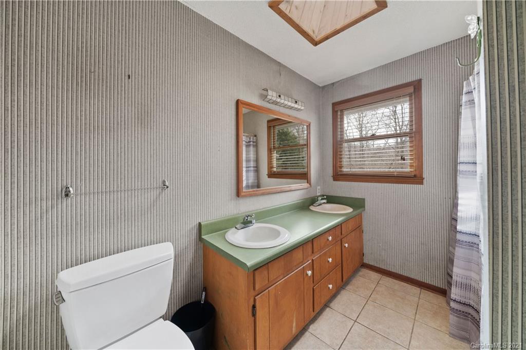 153 Miller Drive Tryon, NC 28782 - Photo 23 of 28 a bathroom with a granite countertop sink and a toilet