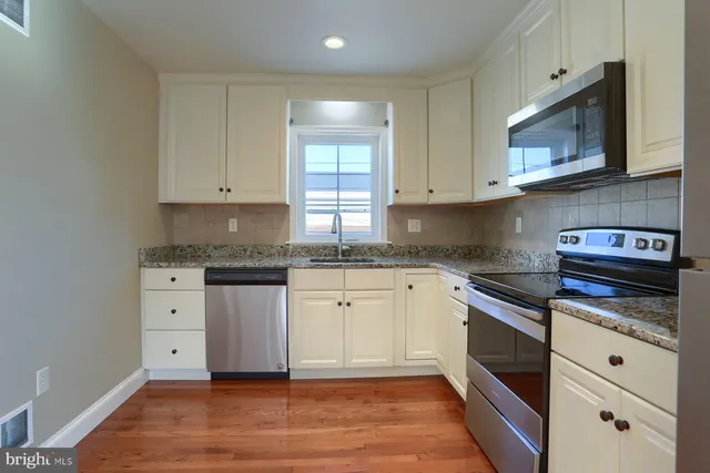 a kitchen with granite countertop white cabinets and white appliances