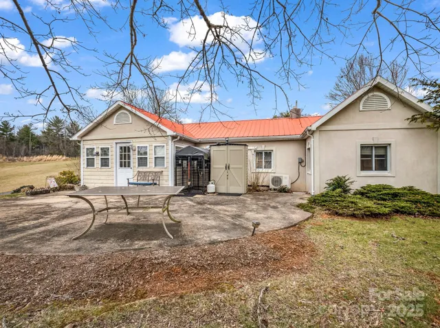 a view of a house with backyard and chairs