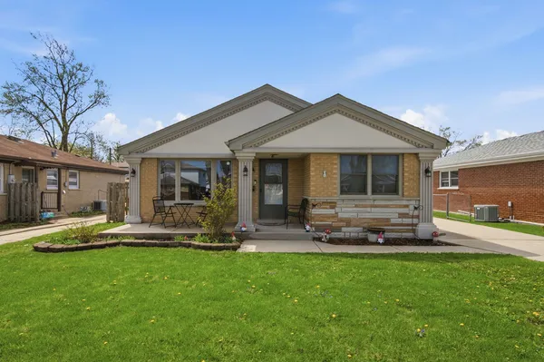 a front view of a house with a yard and patio