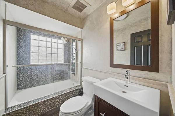 a bathroom with a sink toilet a mirror and shower