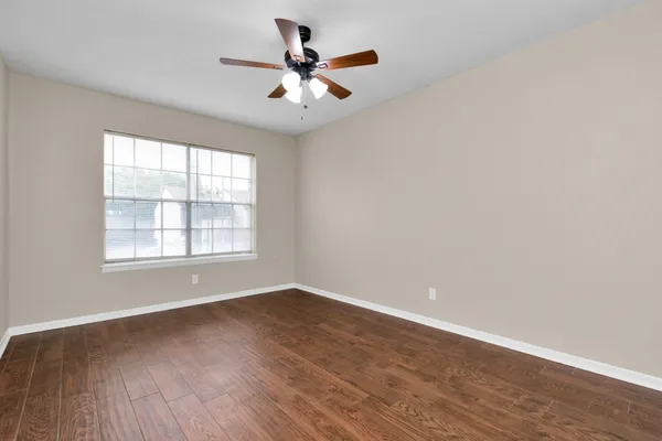 an empty room with fan and windows