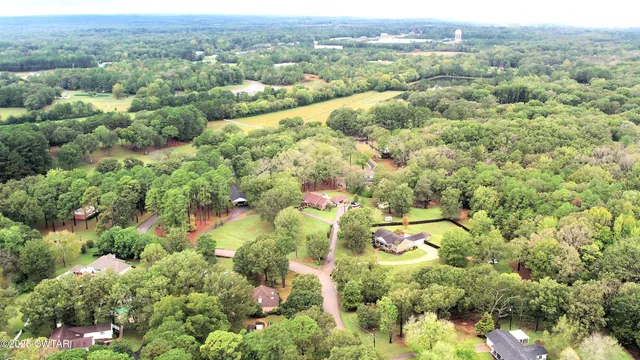 an aerial view of residential house with outdoor space and trees all around