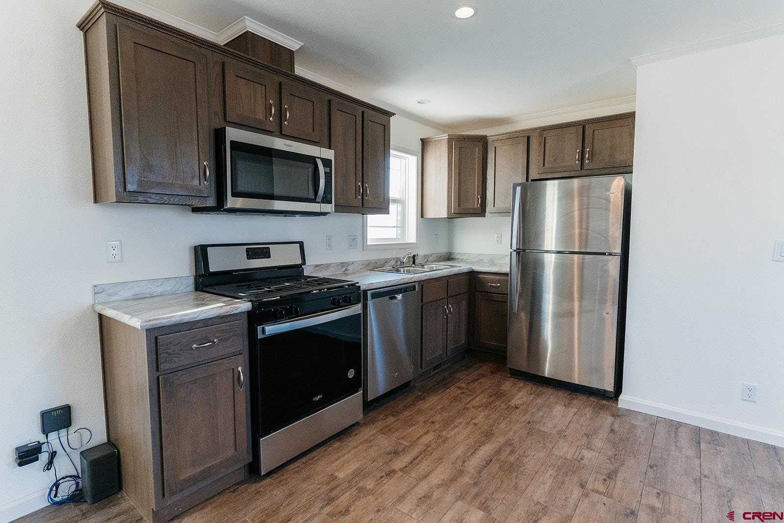 62650 Lasalle Road, Unit 341 Montrose, CO 81403 - Photo 13 of 22 a kitchen with a sink a microwave a refrigerator and cabinets