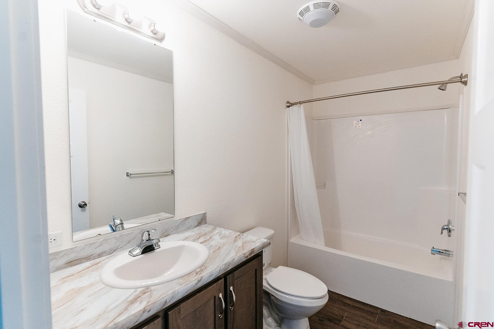62650 Lasalle Road, Unit 341 Montrose, CO 81403 - Photo 8 of 22 a bathroom with a granite countertop sink toilet and shower