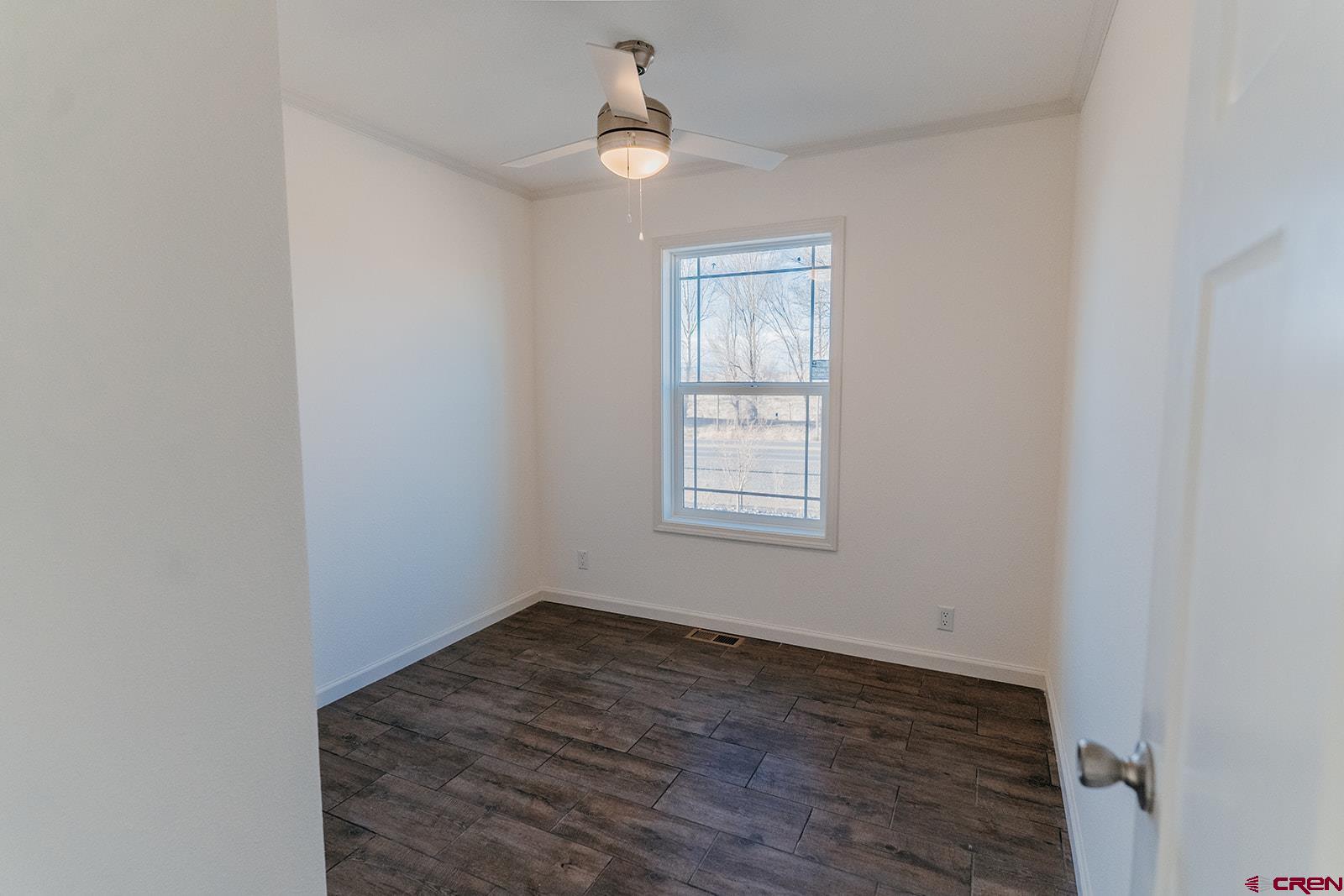 62650 Lasalle Road, Unit 341 Montrose, CO 81403 - Photo 9 of 22 an empty room with wooden floor chandelier fan and windows