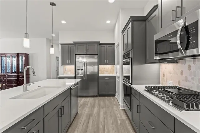 a kitchen with stainless steel appliances granite countertop a sink stove and refrigerator