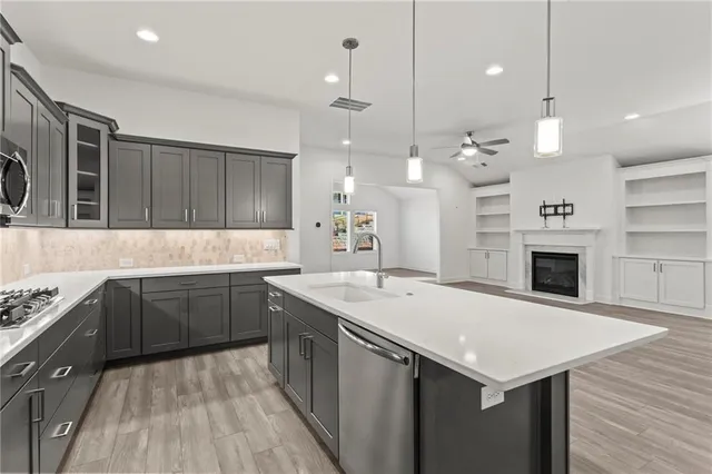 a kitchen with a sink dishwasher a stove and a refrigerator with wooden floor